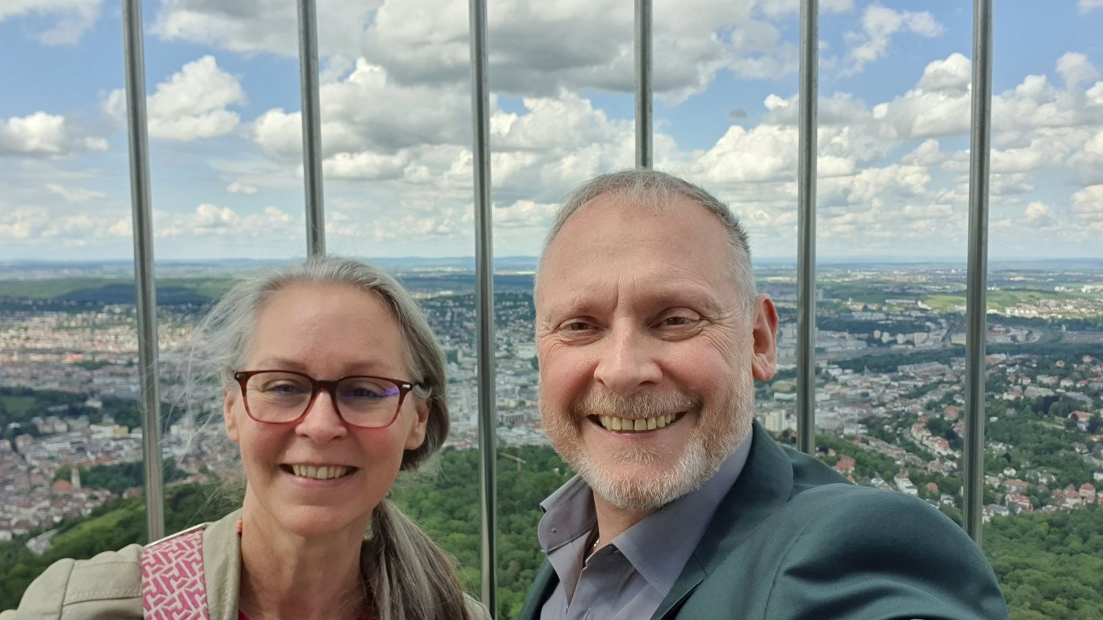 Claudia Schimkowski und Thomas Issler lächeln in die Kamera, im Hintergrund der Blick über Stuttgart