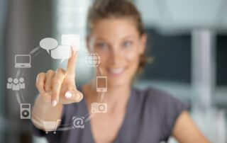 Frau berührt eine Bildschirmoberfläche mit Symbolen für Kommunikation, Online-Shop und soziale Medien