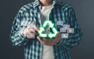 Mann im karierten Hemd hält ein leuchtendes Recycling-Symbol zwischen den Händen