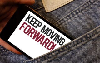 Smartphone in der Hosentasche zeigt den Schriftzug Keep moving forward